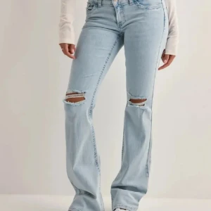 Bootcut ljusblå jeans med slitningar - fint skick, knappt använda. 
