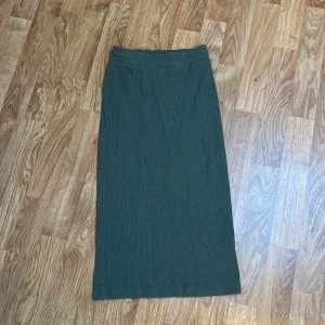 Mörkgrön ribbad långkjol från HM - Mörkgrön långkjol från HM Divided i ribbad trikå. Storlek XS. Resår i midjan. Går precis över knäna på mig som är 160cm lång. Använd fåtal gånger