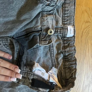 Grå jeans från Crunt med rak passform - Säljer ett par grå jeans från Crunt med klassisk femficksdesign och rak passform. Jeansen har elastisk midja baktill, dragkedja och knapp framtill. Materialet är jeans med en tvättad look som ger en cool vibe. Perfekt för dig som gillar avslappnad stil.