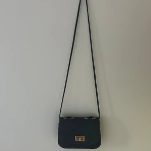 Axelremsväska - Väskan hade orginellt en kedja på axel bandet men saknar det och man har fått knyta en lösning men fungerar jättebra.