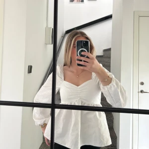 Vit blus med puffärmar och v-ringning - Säljer en jättefin vit blus med v-ringning och puffiga långa ärmar.