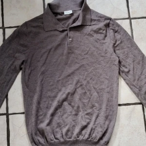 Beige långärmad pikétröja från John Henric - Säljer en beige långärmad pikétröja från John Henric i 100% merinoull. Tröjan har klassisk krage, två knappar och ribbad nederkant. Perfekt för en stilren och bekväm look. Skriv alltid vid minsta fundering.