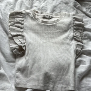 Vit ribbad topp med volangärmar från Zara - Supersöt vit ribbad topp från Zara med volangdetaljer på ärmarna. 🩷 storlek s 
