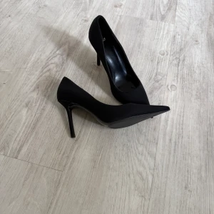 Svarta pumps från mango - Säljer ett par klassiska svarta pumps från mango med spetsig tå och stiletto klack.  Aldrig använda då jag inte kan gå i klackar nypris 500 kr 