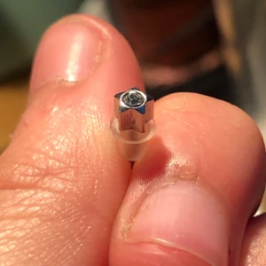Stjärnformade örhängen i guld och silver med stenar i mitten - Säljer ett par små stjärnformade örhängen, en i guld och en i silver, båda med en glittrande sten i mitten. Perfekta som diskreta accessoarer till vardags. Kommer med mjuka bakstycken för extra komfort.