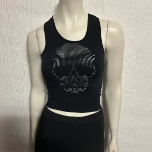 Lite kortare linne. Storlek XXL/XXXL - Lite kortare helt nytt linne med strassdöskalle. Storlek XXL/XXXL. Material i 60% bomull, bamboo och spandex.