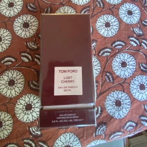Tom Ford Lost Cherry Eau de Parfum 100 ml - Tom Ford Lost Cherry Eau de Parfum i en elegant mörkröd kartong, 100 ml. Parfymen kommer i originalförpackning och har en lyxig känsla med sin stilrena design. Perfekt för dig som gillar exklusiva dofter med körsbärstoner.
