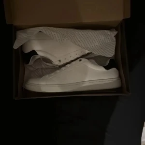 Vita sneakers från Björn Borg - Säljer ett par klassiska vita sneakers från Björn Borg, modell T305 CLS BTM M. Skorna har en stilren design med rund tå och platt sula, perfekta för en clean och enkel look.