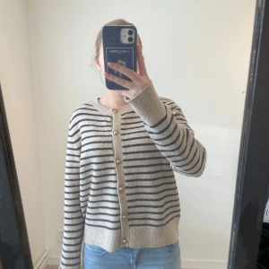 Beige och blå randig kofta från Zara - Säljer en långärmad beige blå randig kofta från Zara med pärlknappar framtill. 