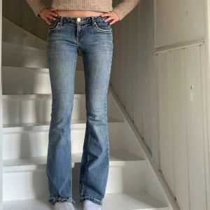 Blå bootcut jeans med låg midja - Snygga blå jeans med bootcut passform och låg midja. Jeansen har klassiska fickor.