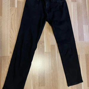 Jeans från Jack and Jones  - Svarta jeansbyxor från Jack and Jones  med klassisk femficksdesign och raka ben. Fint skick 