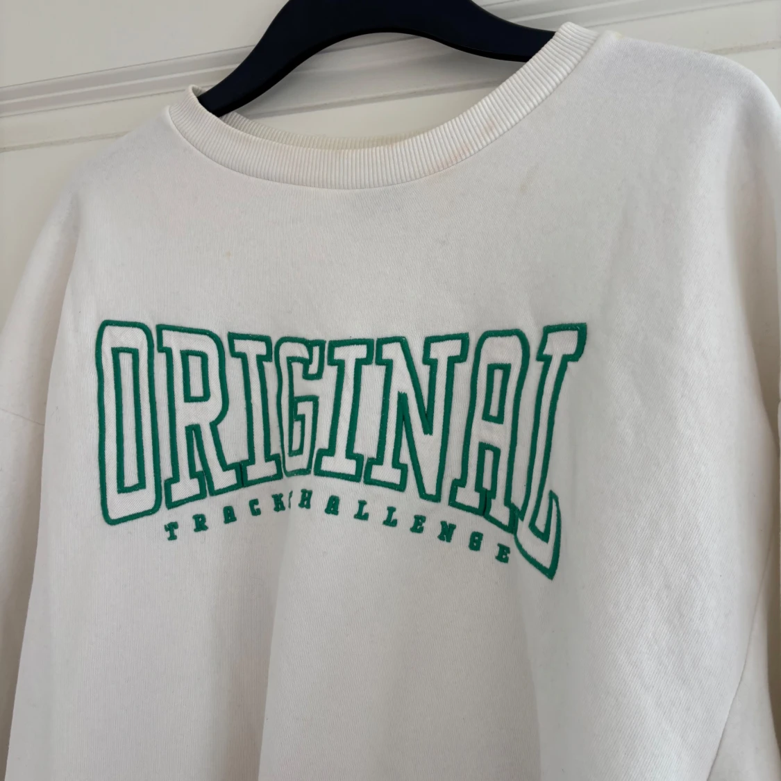 Vit sweatshirt med grön text