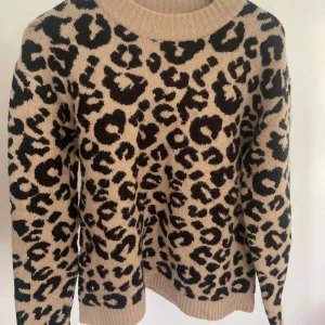 Leopard tröja från NA-KD - Säljer en beige stickad tröja från NA-KD med svart leopardmönster. Tröjan är i storlek S