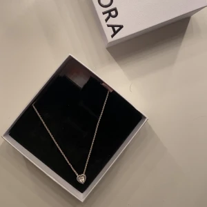Halsband med hjärthänge från Pandora - Säljer ett elegant halsband från Pandora i sterlingsilver med ett gnistrande hjärthänge omgivet av små stenar. Perfekt för dig som vill ha ett smycke som sticker ut och känns extra speciellt. ( kan gå ner i pris vid snabb affär )