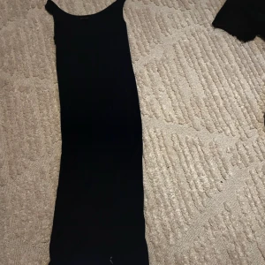 Marinblå långklänning från Marine Classic - Säljer en enkel och stilren marinblå långklänning från Marine Classic i storlek S. Klänningen är ärmlös och har en rak, tight passform som passar perfekt till sommaren. Perfekt för dig som gillar minimalistisk stil.