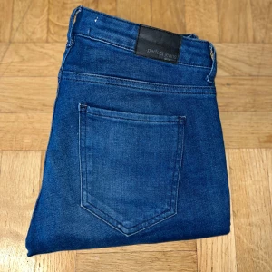 Blå jeans med dragkedjor  - Ursnygga par blåa jeans från Gina Tricot med tre dragkedjor framtill och snygga quiltade detaljer över knäna. Byxorna har en slim passform och femficksdesign! 💙
