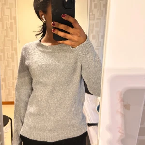 Ljusgrå stickad  - Mysig ljusgrå stickad tröja från Vero Moda. Tröjan har rund halsringning och långa ärmar