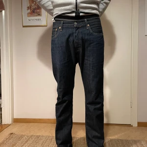 Levi's 501 jeans i mörkblå denim - Säljer ett par Levi's 501 jeans i mörkblå denim. De har en rak passform och är i mycket bra skick. Passar på någon som är 190 men går även att vika upp snyggt.