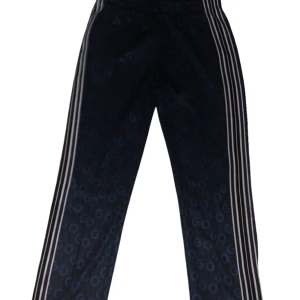 Mörkblå träningsbyxor med mönster från HUGO - Snygga mörkblå träningsbyxor från HUGO med blått GO-mönster över hela tyget. Byxorna har vita ränder längs sidorna och dragkedjor vid bensluten. Resår i midjan och en bakficka. Perfekta för en sportig look. 1Riktigt ovanliga] ny pris 1300