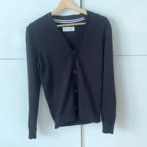  Pier One cardigan - En klassisk svart kofta från Pier One med knäppning framtill. Tröjan har lång ärm och en enkel, stilren design som passar till mycket. Perfekt för lager-på-lager och enkel att matcha med andra plagg.