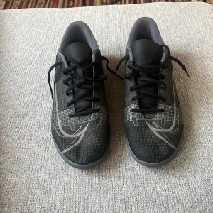 Svarta fotbollsskor från Nike - Snygga svarta Nike Mercurial fotbollsskor med grå detaljer och snörning.  Säljer de nu för de passar inte längre knappast använda 