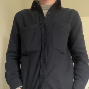 Mörkblå overshirt/skjortjacka från A Day's March - Säljer en stilren mörkblå overshirt från A Day's March. Den har knappar framtill och två bröstfickor. Storlek small, köpt för 1500 kronor, säljer för 499 kr, mycket bra skick, säljer för den börjar bli lite liten. Modellen är 182 cm och väger 64 kg