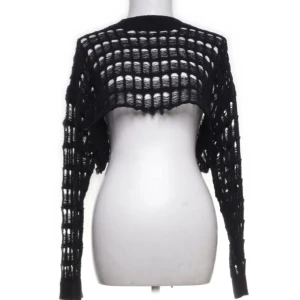 Svart stickad bolerotopp från Reclaimed Vintage - Säljer en svart stickad bolerotopp från Reclaimed Vintage, köpt på Sellpy men tyvärr aldrig använd. Den har ett coolt stickmönster och är croppad med långa ärmar, perfekt att ha över ett snyggt linne 