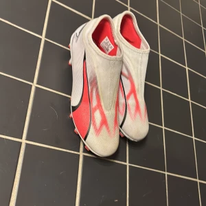 Vita och röda fotbollsskor från Puma - Säljer ett par stilrena fotbollsskor från Puma. Storlek 36 men passar lite större. Säljer för dom har blivit för små. Tveka inte på att höra av er.