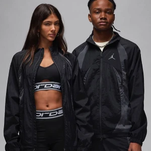 Jordan warm up jam set (tsm med byxor) - Snygg svart vindjacka från Jordan med dragkedja och ikonisk logga på bröstet. Jackan har en sportig look med långa ärmar och är perfekt för träning eller vardagsbruk. Tillverkad i lätt syntetmaterial för komfort och stil.