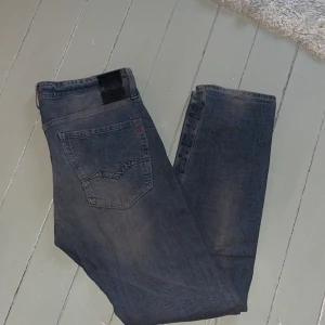 Mörkblå jeans från Replay - Snygga mörkblå jeansbyxor med en klassisk femficksdesign. De har en slim passform och är perfekta för en avslappnad stil. Byxorna har en diskret tvättad look som ger dem en trendig touch.