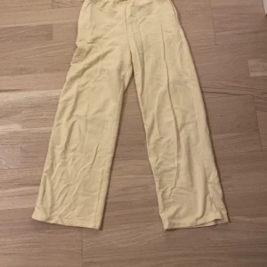 Gula mjukis byxor från H&M - Säljer ett par bekväma gula byxor från H&M. De har en elastisk midja och är tillverkade i mjukt bomullsmaterial. Perfekta för en avslappnad stil.