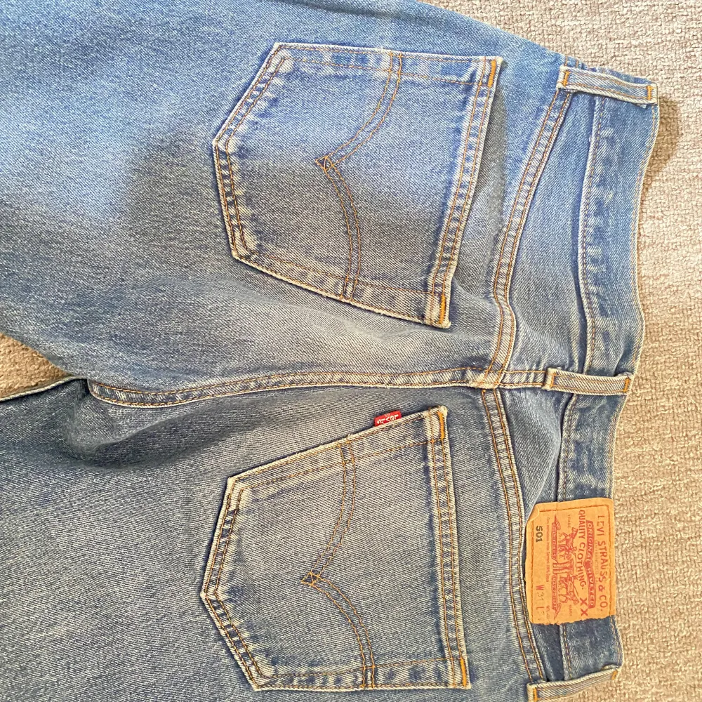 Klassiska blå Levi's jeans med en bekväm passform. De har en traditionell design med en knappgylf.. Farkut & Housut.