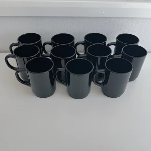 11st svarta kaffekoppar  - 11st svarta kaffekoppar från IKEA som är flitigt använda och har små tecken på användning men inget man tänker så mycket på. Det är lite vatten fläckar från efter disk och lite damm då dom bara stått i skåpet och samlat damm. Dom diskas såklart innan postning! FÖRST TILL KVARN!