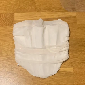 Vit korsett topp från Gina Tricot - Snygg vit beige korsett topp från Gina Tricot med snörning bak för en justerbar passform. Perfekt för sommaren och utekvällar. 