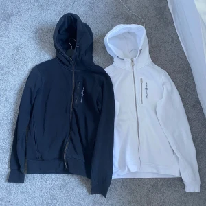 Svart och vit huvtröja från Sail Racing - Säljer två sail racing hoodeies för 700. Båda har dragkedja framtill och en praktisk bröstficka med dragkedja. Knappt använd nån av dom 