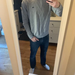 Grå tröja från Lee - Säljer en stilren grå tröja från Lee i storlek S men sitter som en M. Tröjan har en enkel design med Lee-loggan broderad på bröstet. Den är långärmad och har en rund halsringning. Perfekt för en avslappnad look.