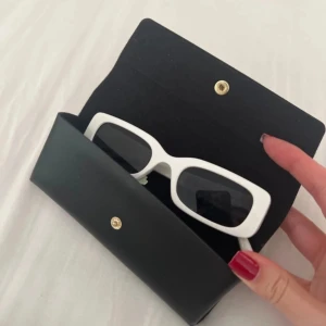 Vita rektangulära solglasögon - Zalando - Snygga vita solglasögon med rektangulära bågar. Perfekta för en stilren look. Kommer med ett svart fodral för säker förvaring.