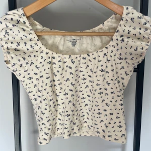 Brandy Melville top - Brandy Melville top i benvit med marinblå blommor. Jättefint mönster och fin topp till sommaren 💙🌸