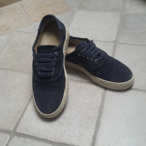 Mörkblå sneakers med snörning - Snygga mörkblå sneakers i mocka med snörning och en ljus sula. Perfekta för en avslappnad stil och passar till många olika outfits.