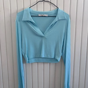 Ljusblå ribbad topp från na-kd - Snygg ljusblå croppad topp från nakd. Säljes då den inte kommer till användning💙