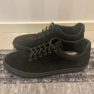 Svarta sneakers från North - Snygga svarta sneakers från North i mocka med snörning. Perfekta för en stilren look. 