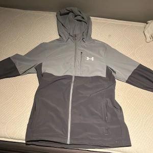 Under Armour - Säljer en grå vindjacka från Under Armour. Den är perfekt till sommaren. Stolek S.