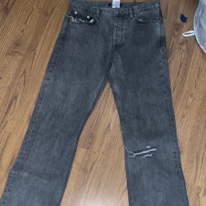 Grå jeans från Hope - Size 28. Skönhetslitage på vid knäet