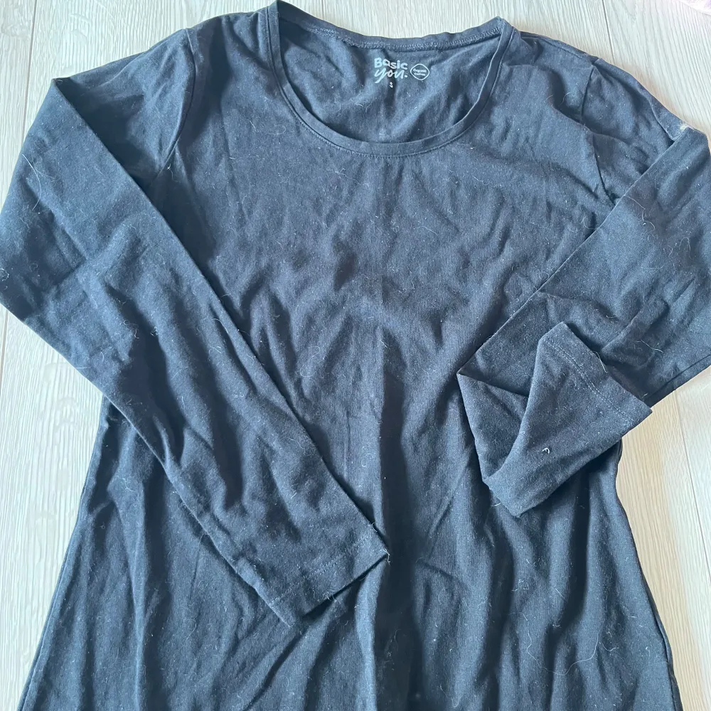 Säljer en svart långärmad tröja från Basic You, tillverkad i ekologisk bomull. Perfekt för en enkel och stilren look. Tröjan har en rund halsringning och är i en bekväm passform.🩷. Neuletakit & Villapaidat.