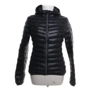 Svart dunjacka med huva - svart dunjacka med huva och dragkedja framtill från everest.Jackan har en quiltad design och långa ärmar, perfekt för kyligare dagar. Storlek 34