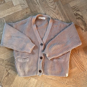 Beige stickad kofta - Säljer en fin kofta från i dig denim i storlek 130/140, tröjan är lite större i modellen och perfekt för en mysig höstdag!