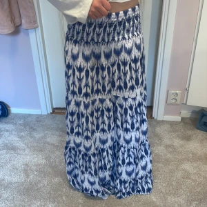 Blåvit långkjol från Gina Tricot - Supersnygg långkjol från Gina Tricot i blått och vitt med ett coolt mönster. Jag har använt en gång. Skriv om ni vill ha mer bilder eller annan information 🫶🏼💕