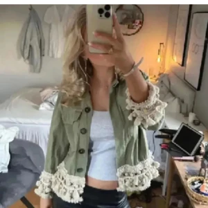 Grön jacka Zara - Snygg ljusgrön overshirt med stora knappar och två bröstfickor. Jackan har unika virkade detaljer och tofsar i beige längs ärmslut och nederkant. Perfekt för dig som vill sticka ut med en kreativ och bohemisk stil.