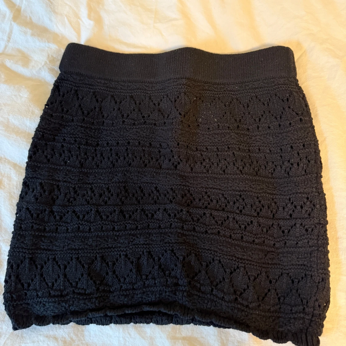 Svart stickad kortkjol med mönster