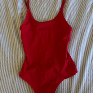 Röd body - Röd body med justerbara band, aldrig använd!!